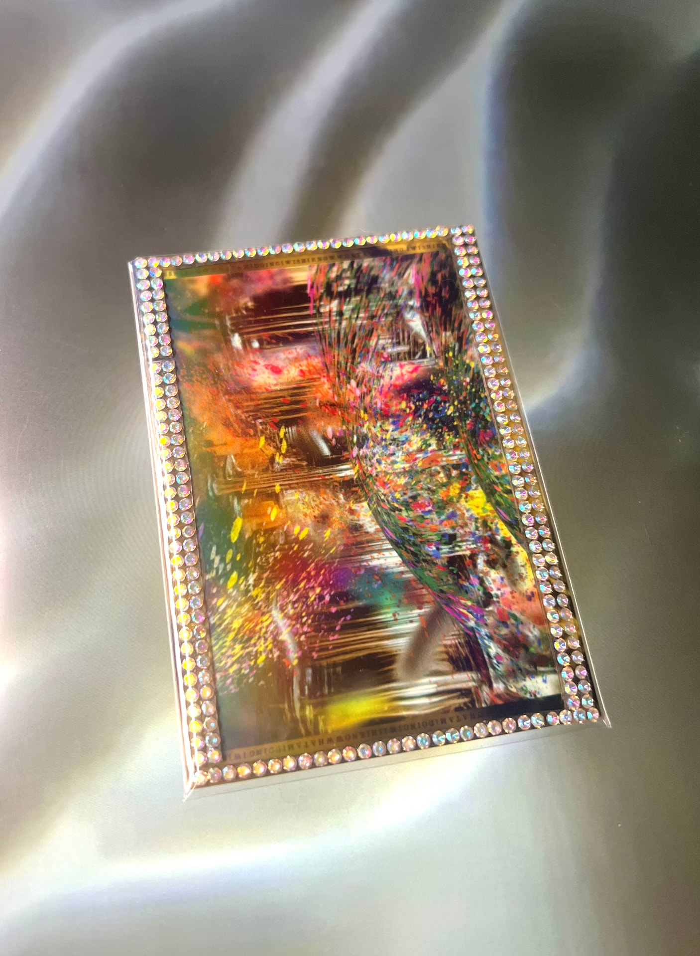 Yifei Gao Experimental Card with rhinestone border on a silver surface